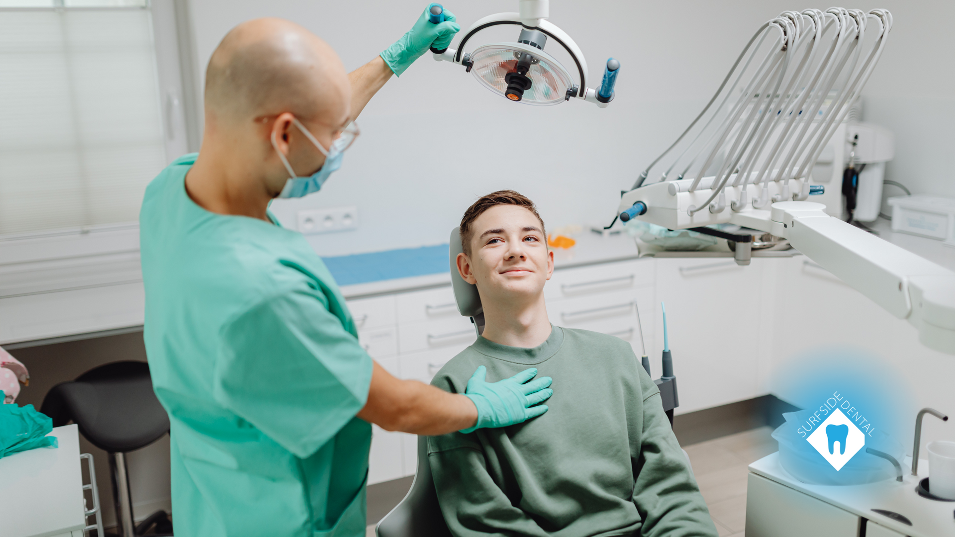 A man is sitting in a dental chair while a dentist examines his teeth.