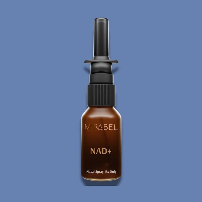 Brown nasal spray bottle labeled "NAD+" against a blue background.