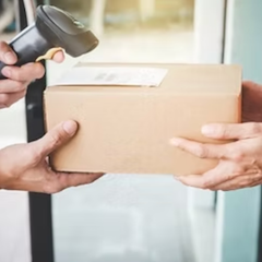 A person scans a package with a barcode reader while another receives the box.