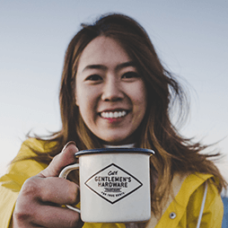 Woman in yellow jacket smiles, holding a 