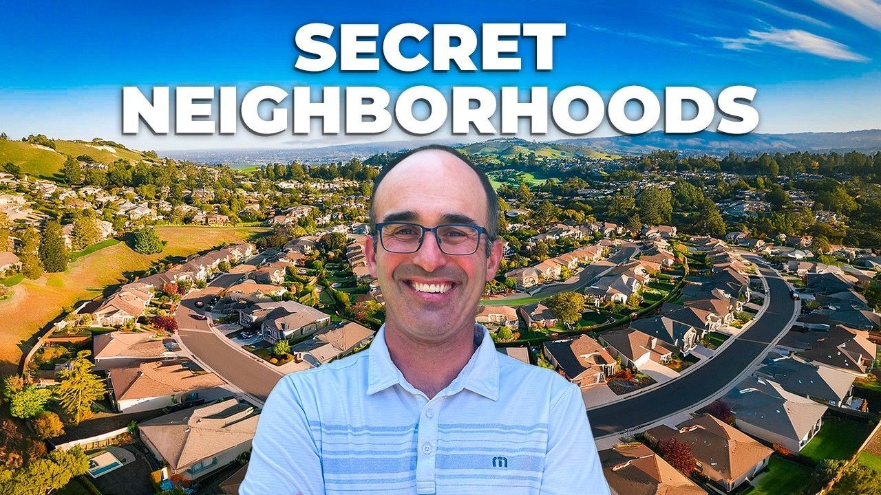 Man smiling, in front of suburban houses, the words