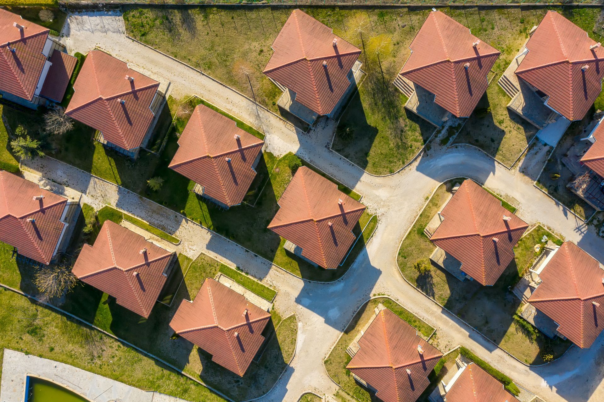 An aerial view of a residential area with lots of houses and a pool.