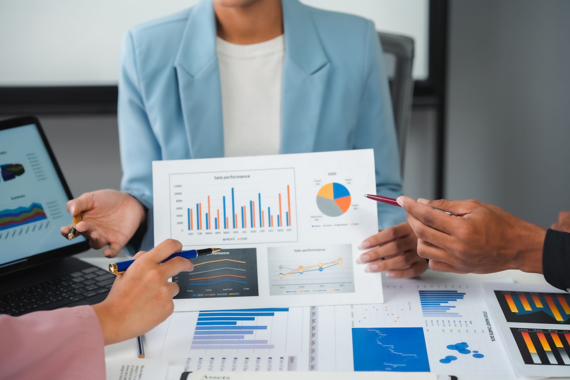 A group of people are sitting around a table looking at graphs.