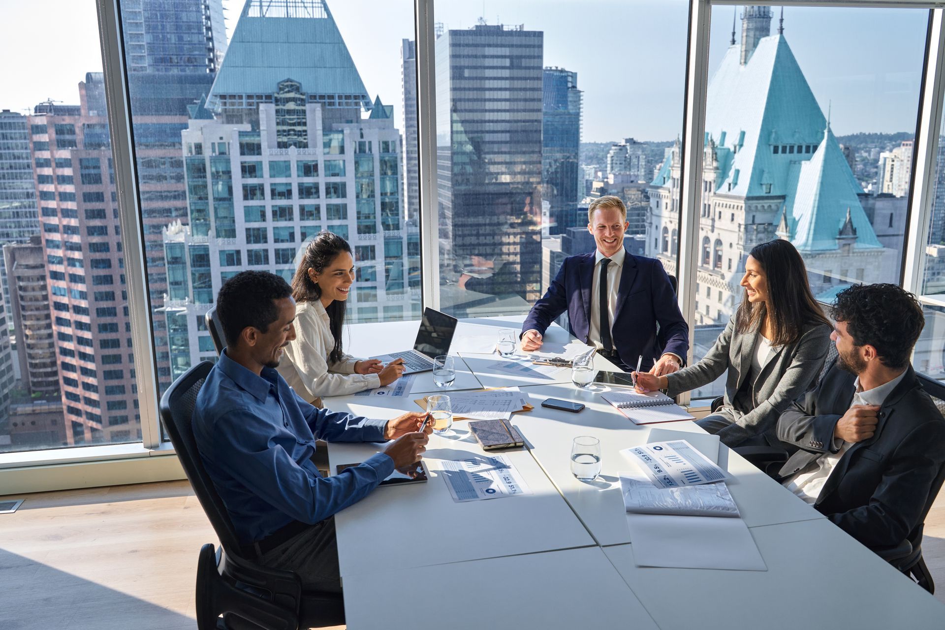 A group of people are sitting around a table in a conference room.