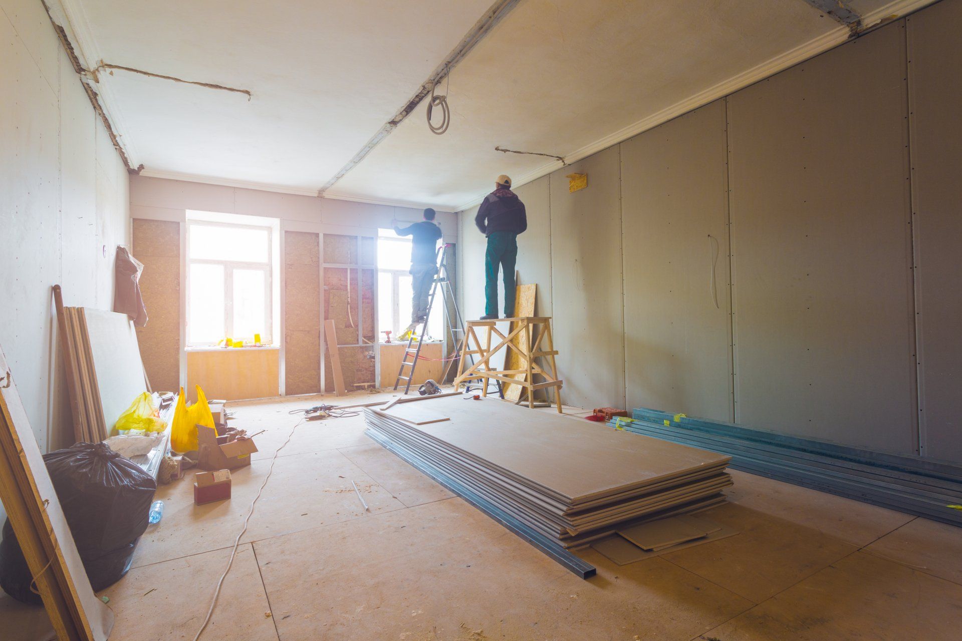 Workers are installing plasterboard (drywall) for gypsum walls in apartment is under construction, remodeling, renovation, extension, restoration and reconstruction.