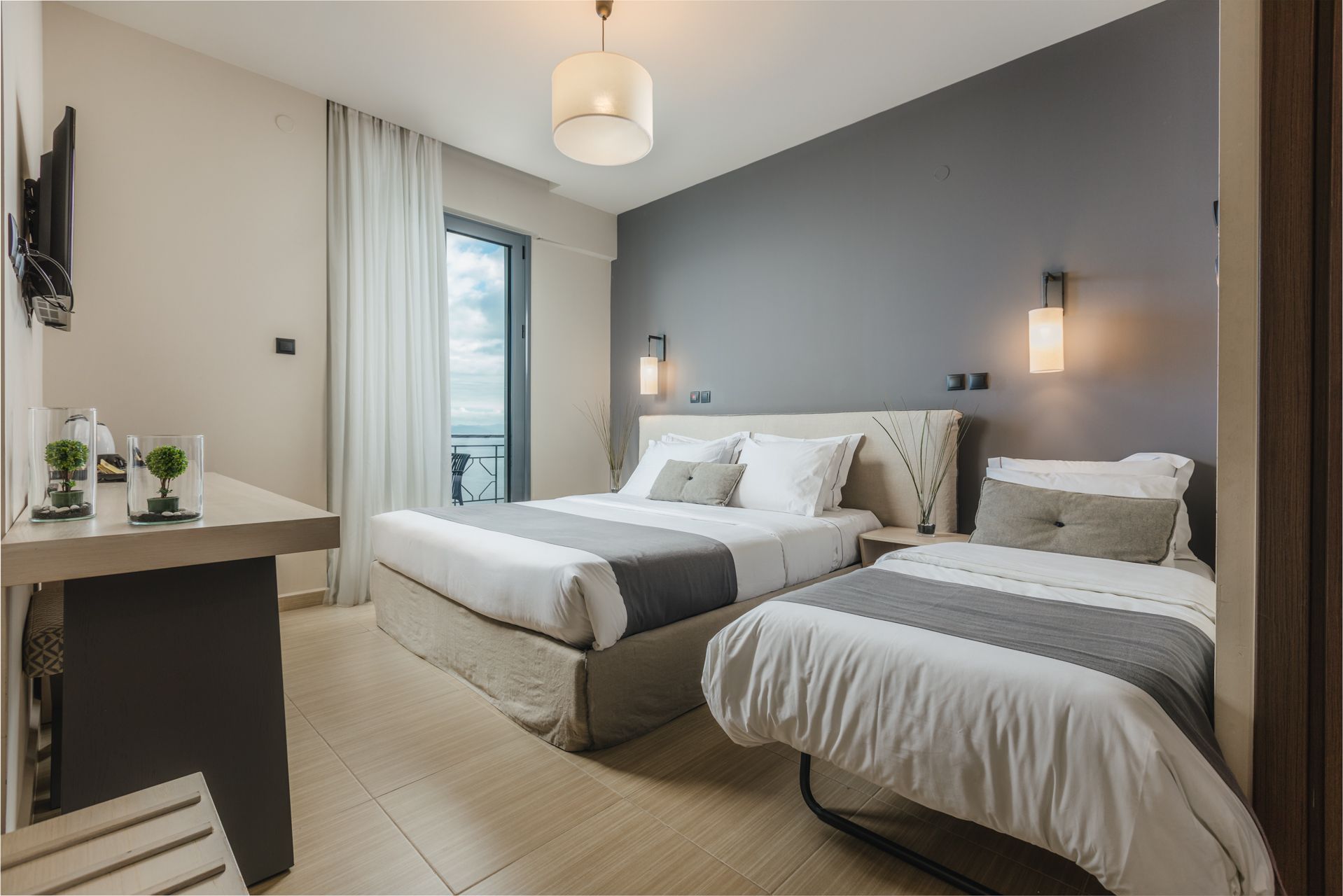 A hotel room with two beds , a desk and a television.