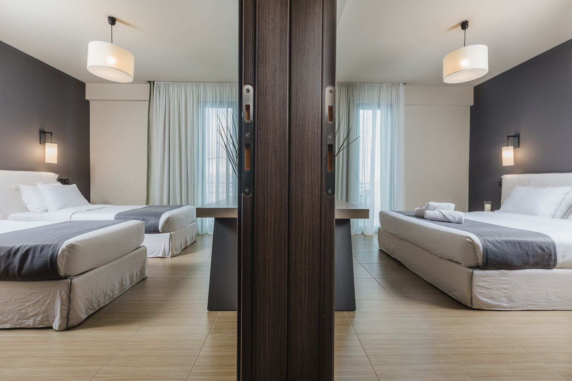 A hotel room with two beds and a mirror.