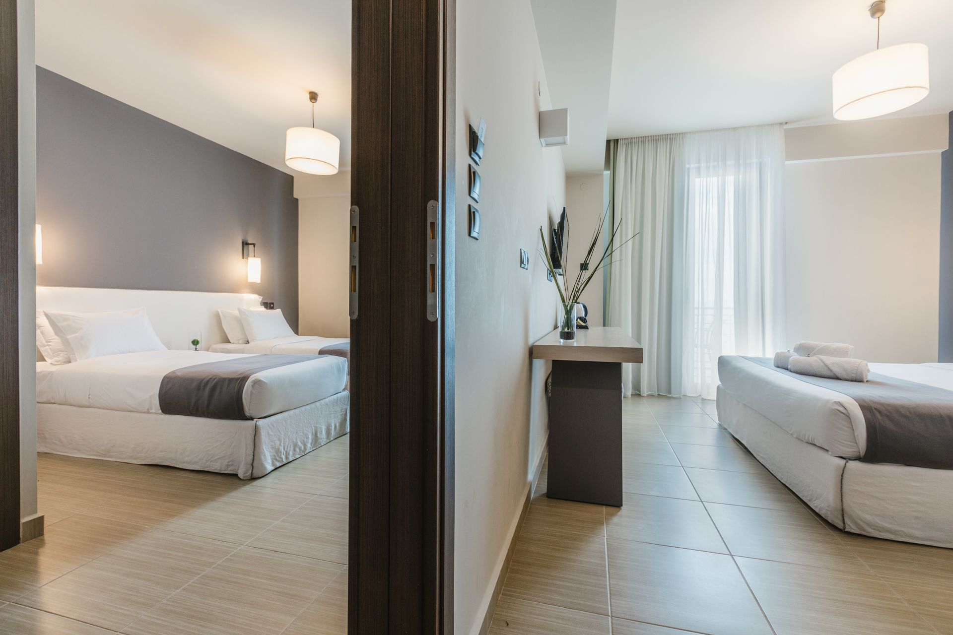 A hotel room with two beds and a table.