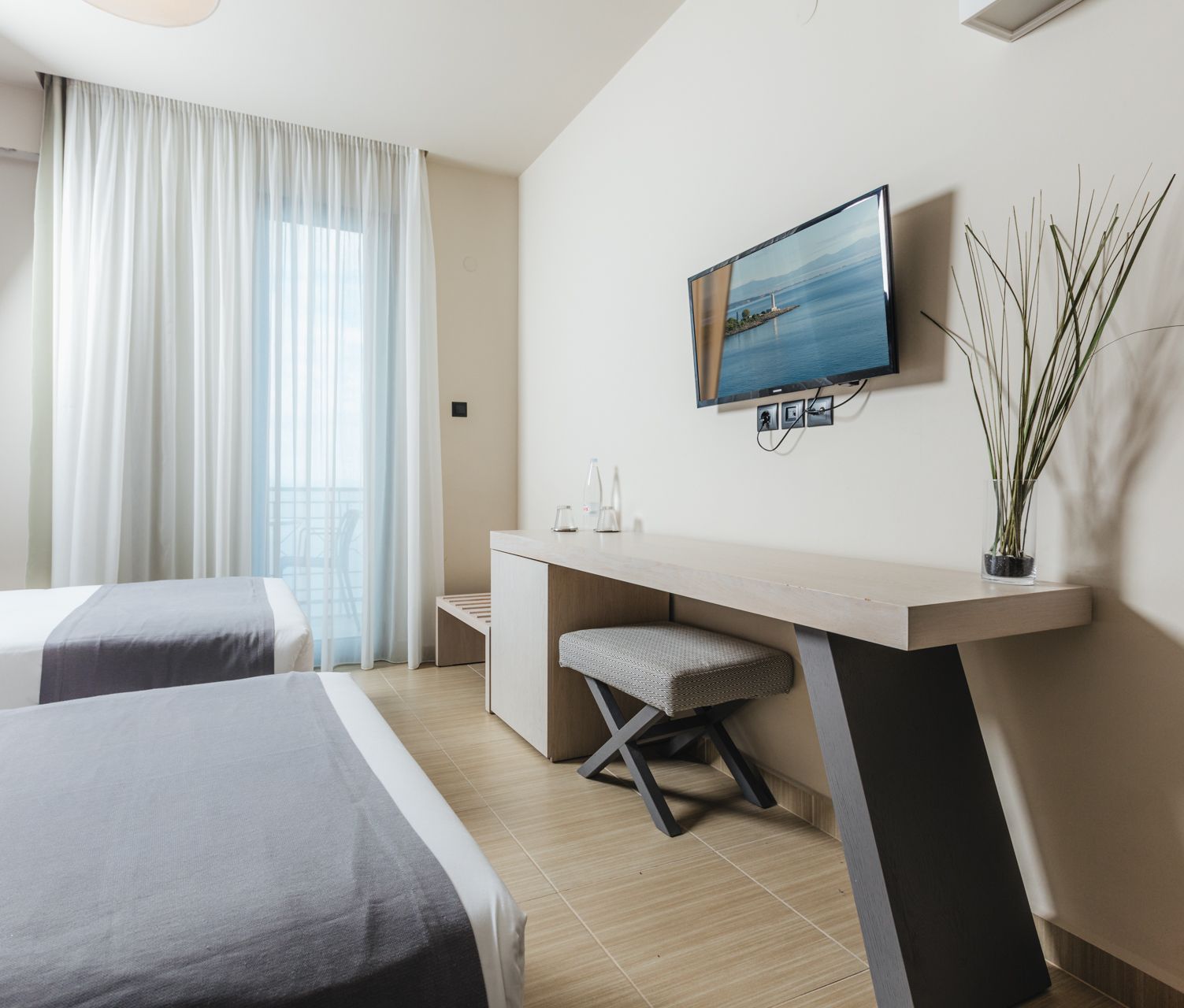A hotel room with two beds and a flat screen tv