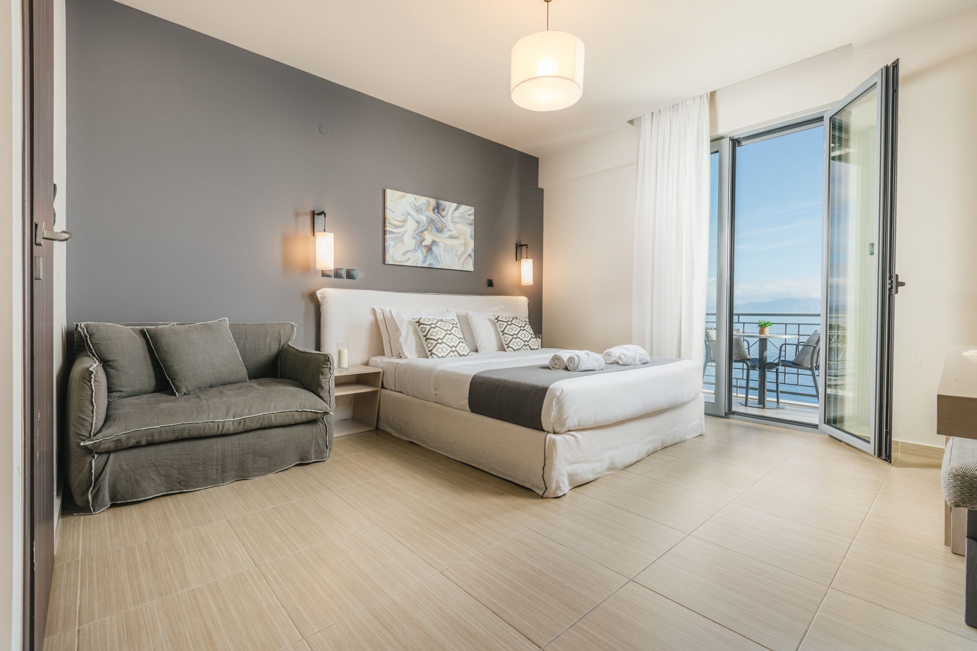 A hotel room with a large bed and a couch.