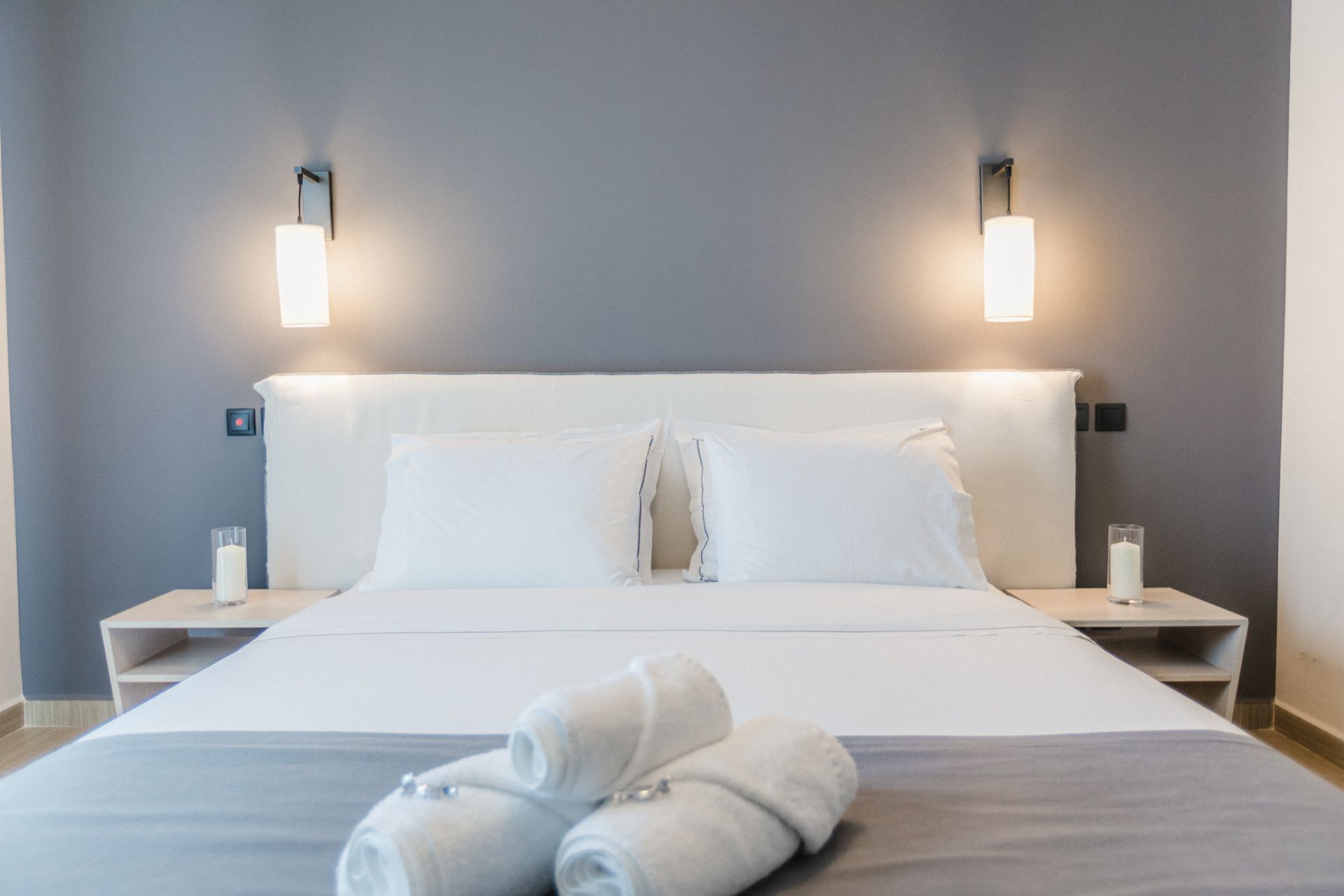 A hotel room with a king size bed and two towels on the bed.