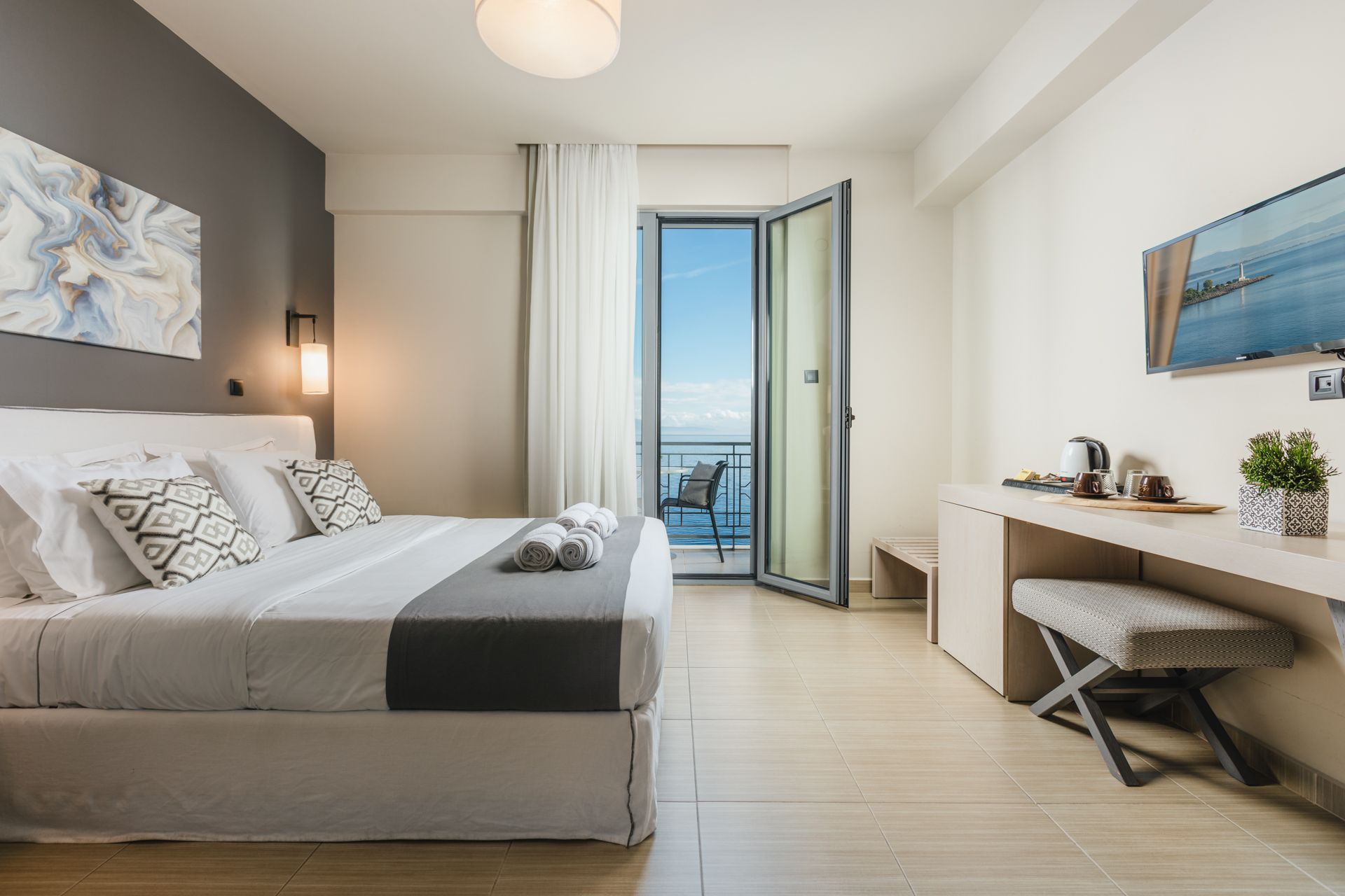 A hotel room with a king size bed and a balcony.