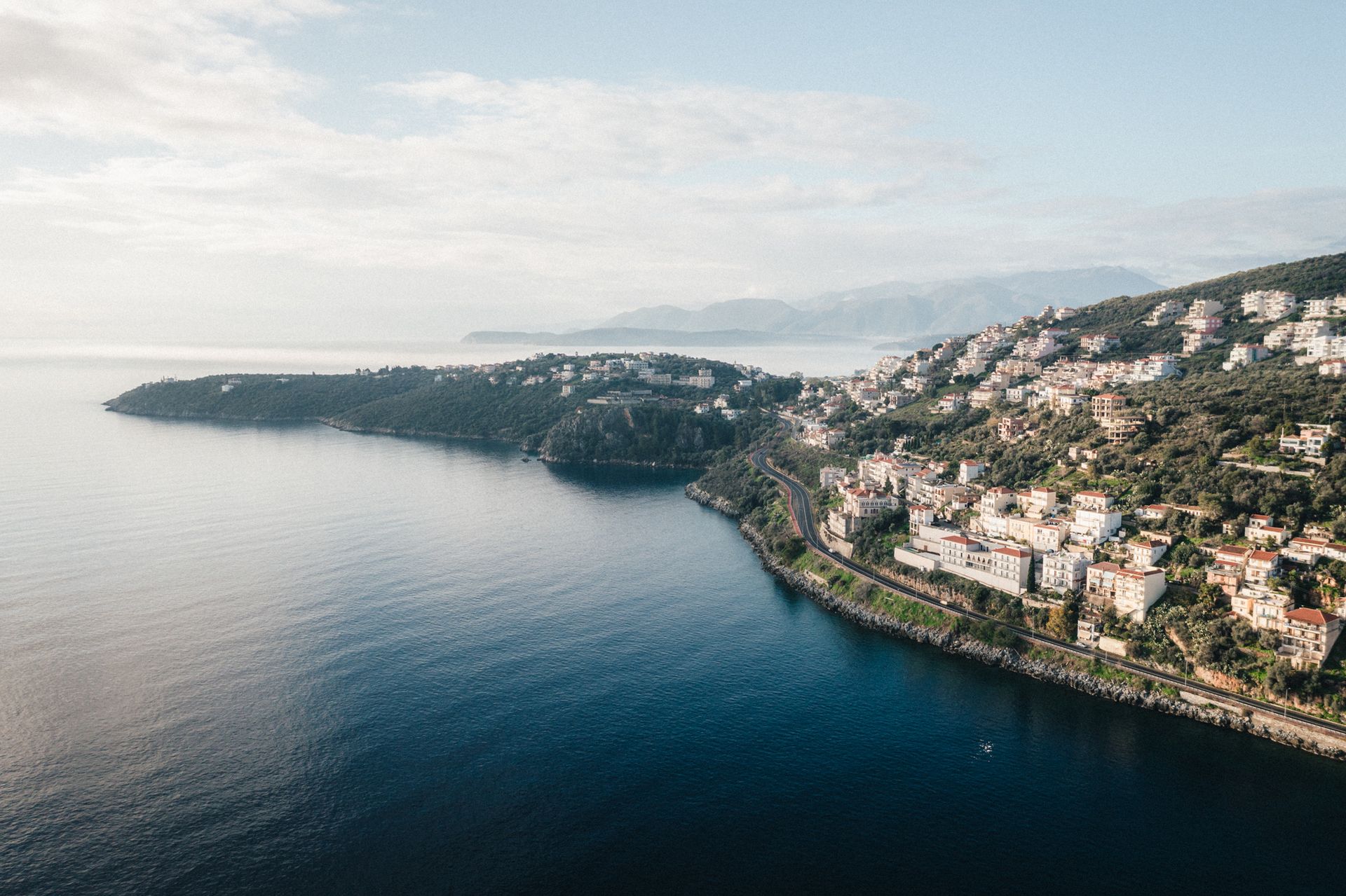 An aerial view of a small town on the shore of a large body of water.