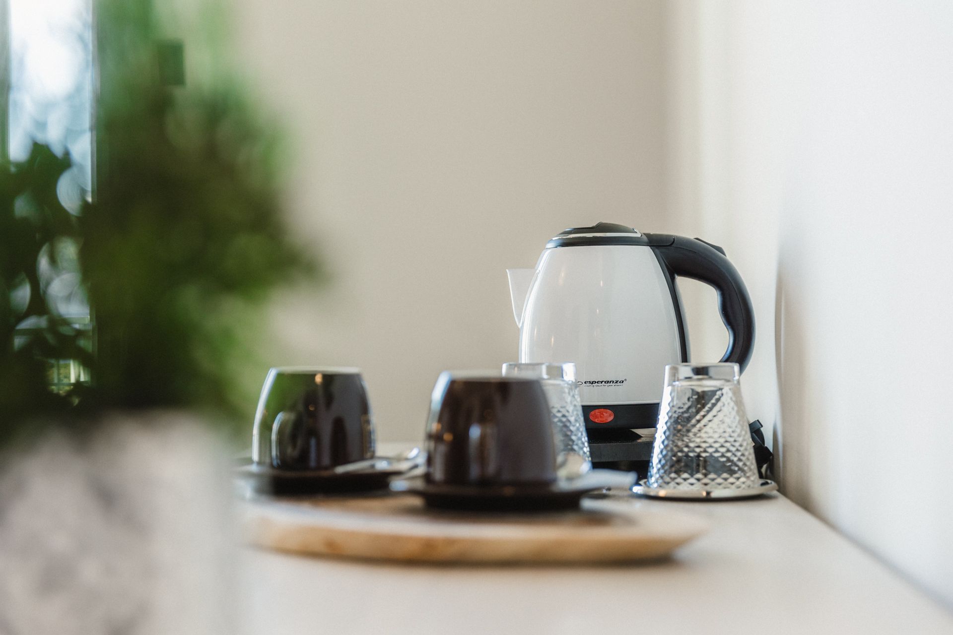 A table with a kettle , cups and saucers on it.