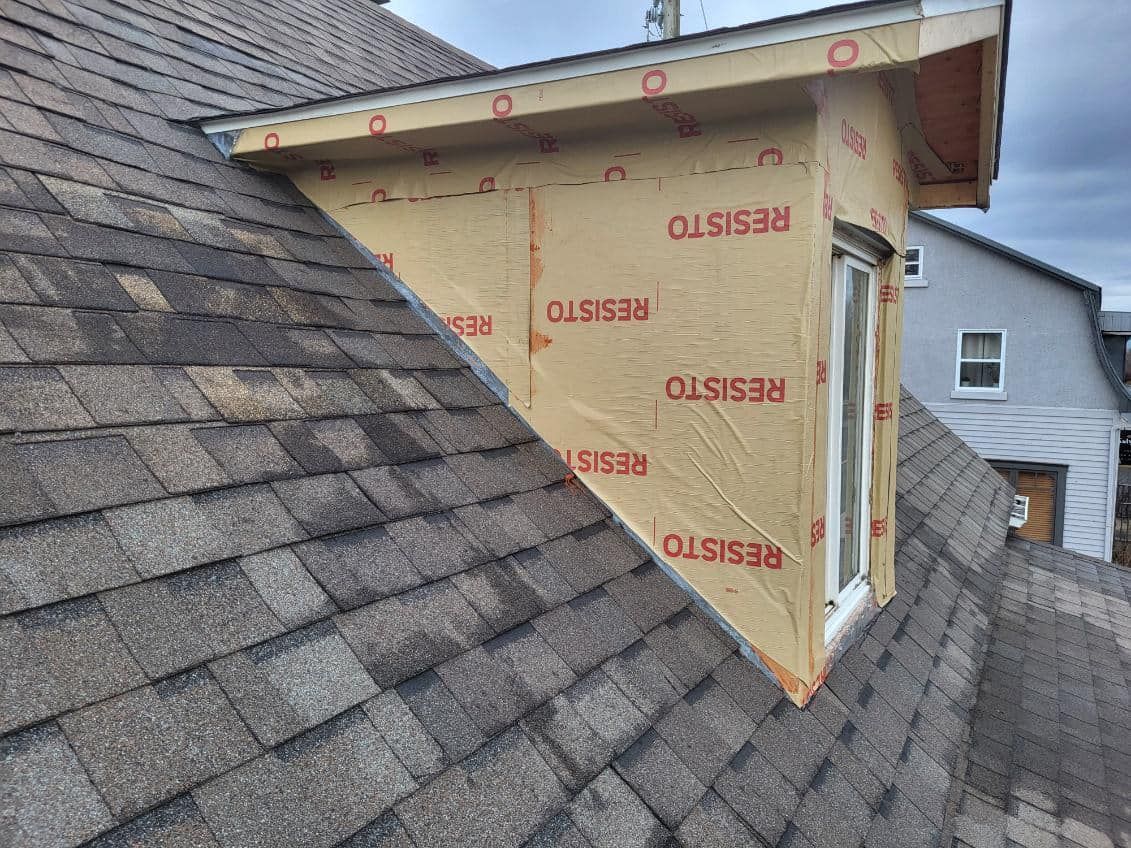 Un toit avec des bardeaux et une fenêtre dessus.