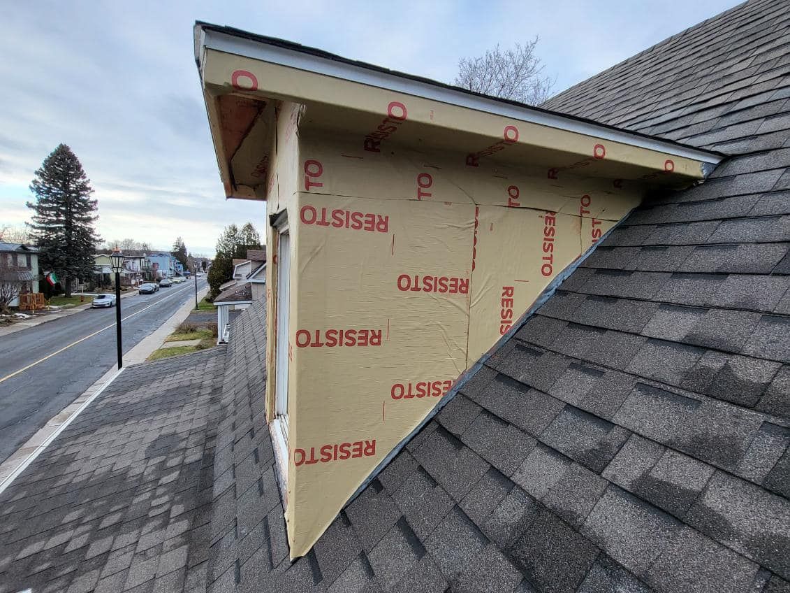 Une maison avec un toit qui a un triangle dessus