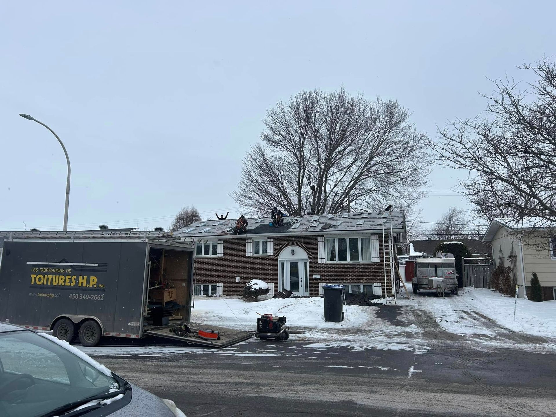 Un camion est garé devant une maison sous la neige.