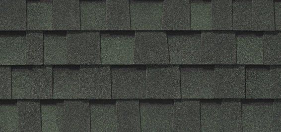 Un gros plan d'un toit avec des bardeaux verts.