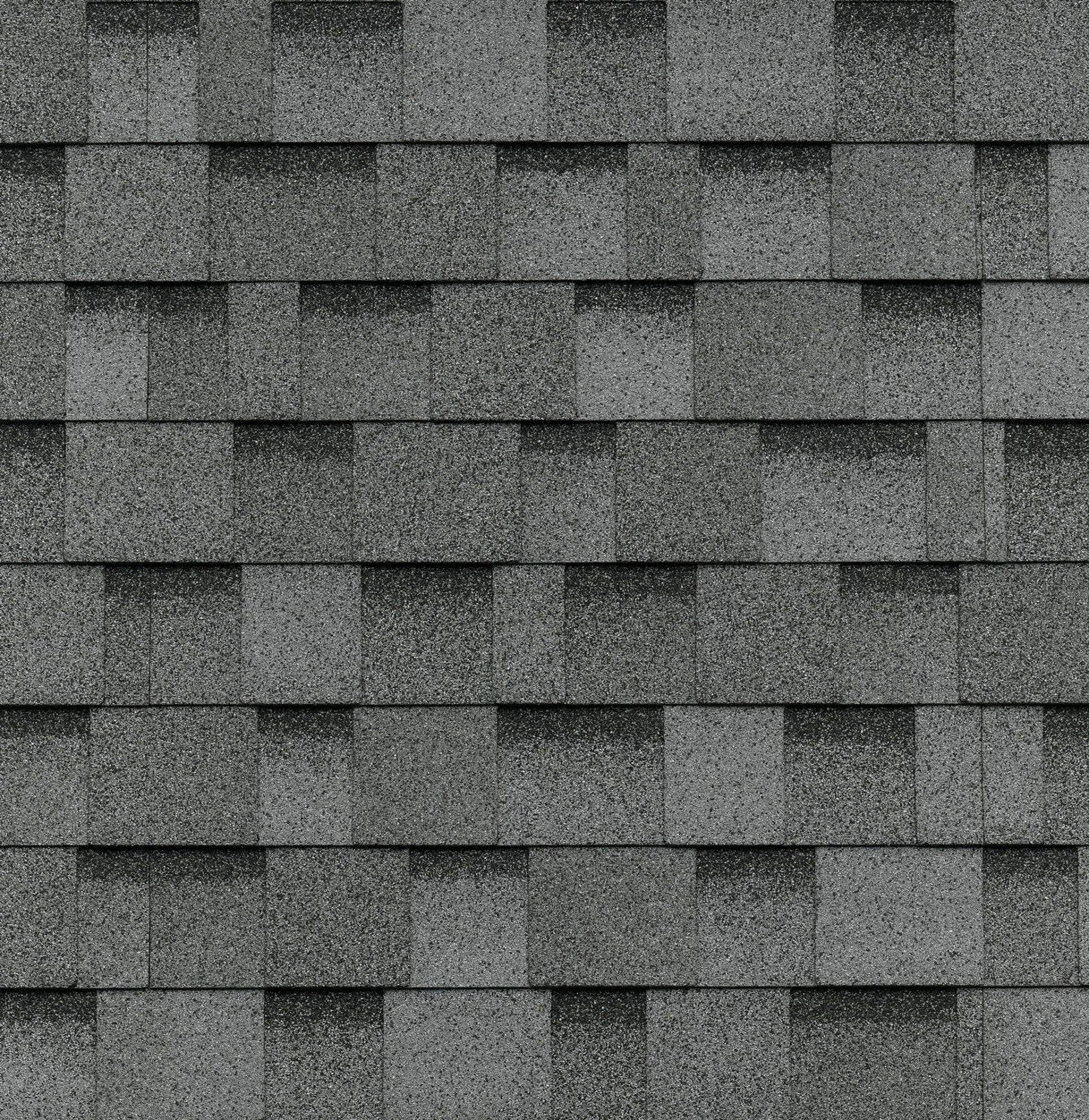 Un gros plan d'une rangée de bardeaux gris sur un toit.