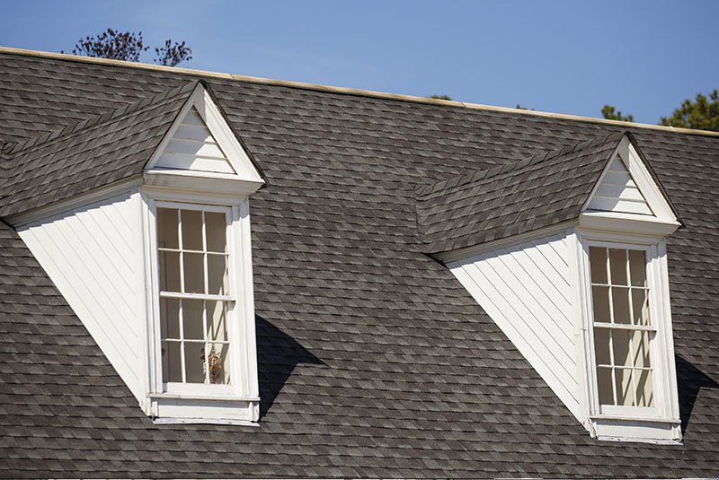 Il y a deux fenêtres sur le toit d'une maison.