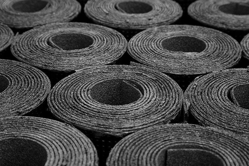 Une photo en noir et blanc de rouleaux de toiture en asphalte.
