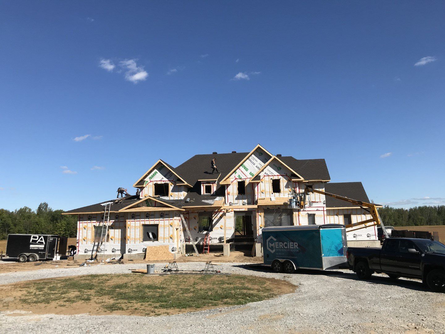 Une grande maison est en construction avec une remorque attachée à elle.