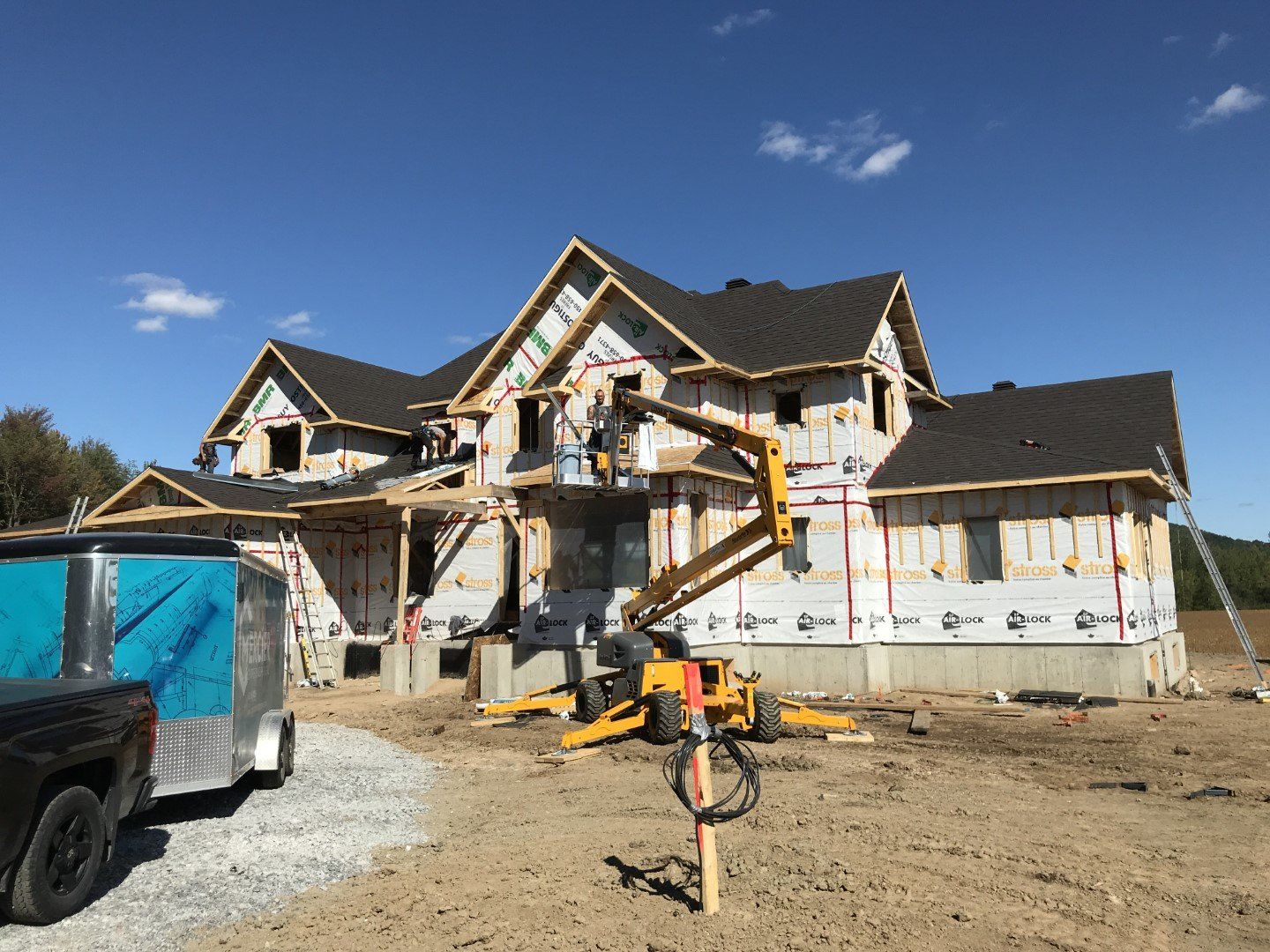 Une grande maison est en construction avec une grue devant elle.