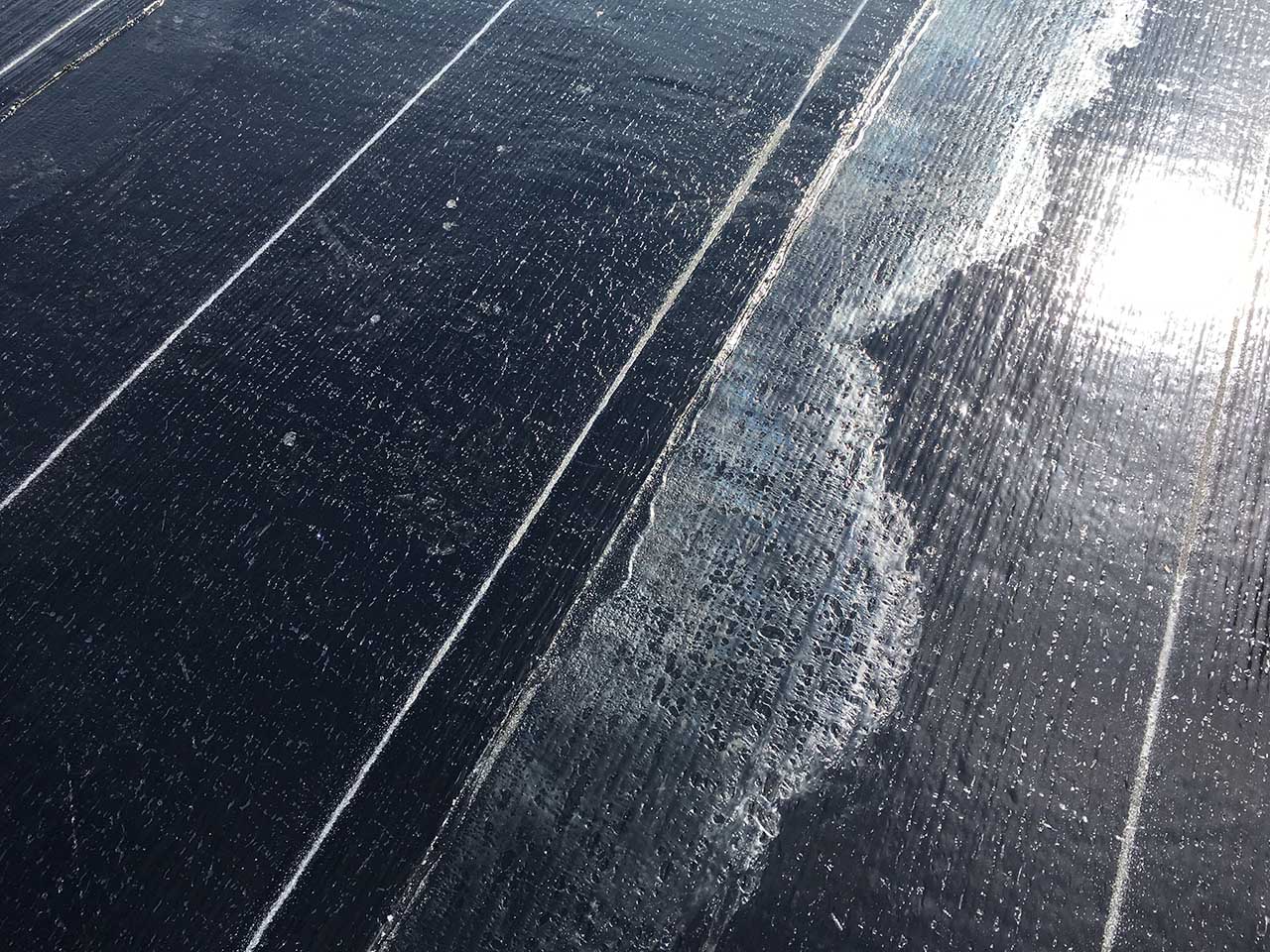 Un gros plan d'une surface noire avec des lignes blanches