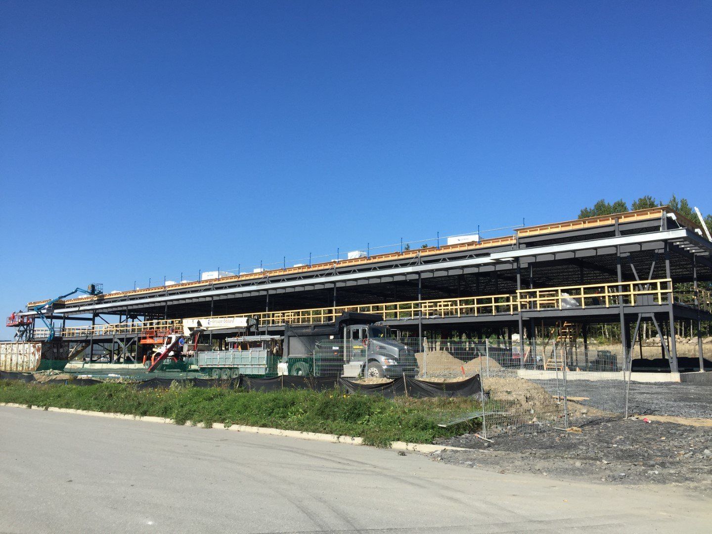 Un grand bâtiment en construction avec un camion garé devant.