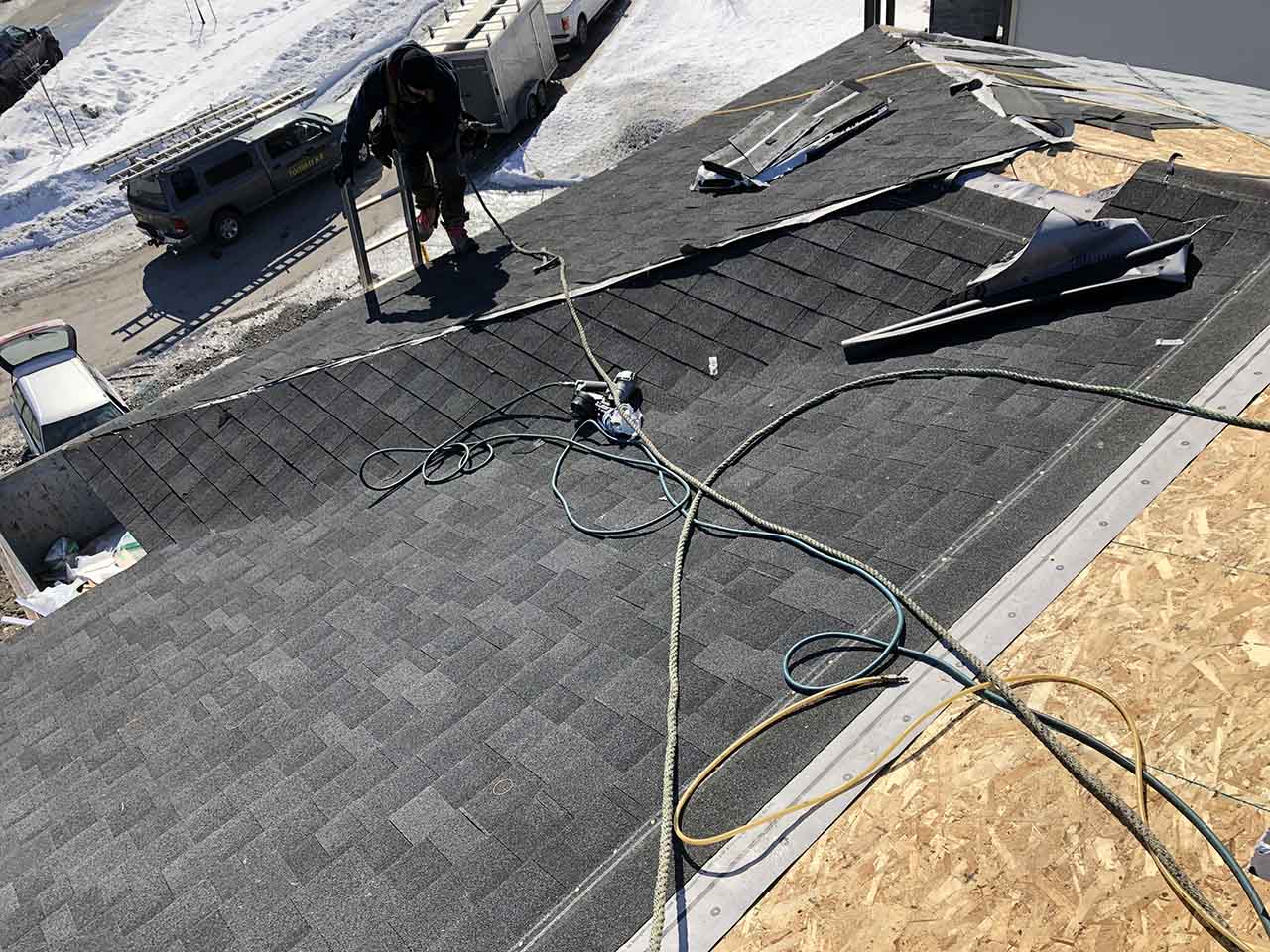 Un homme travaille sur un toit avec un tuyau.