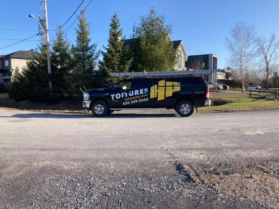 Un camion de toiture est garé sur le bord de la route