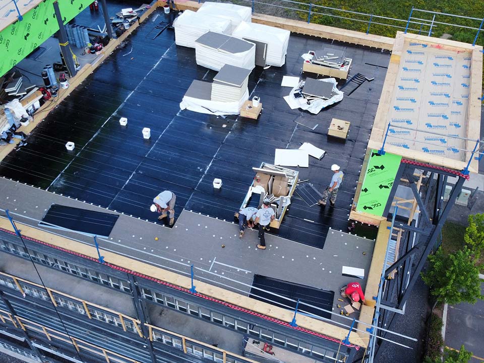Un groupe de personnes travaille sur le toit d'un bâtiment.