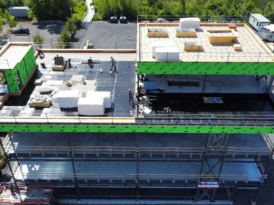 Une vue aérienne d'un bâtiment en construction avec des ouvriers sur le toit