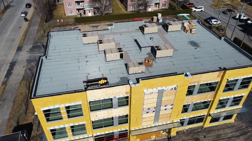 Une vue aérienne d'un grand bâtiment jaune en construction.