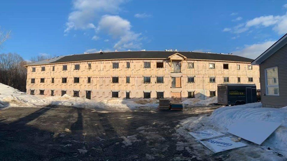 Un grand bâtiment est en construction sous la neige.