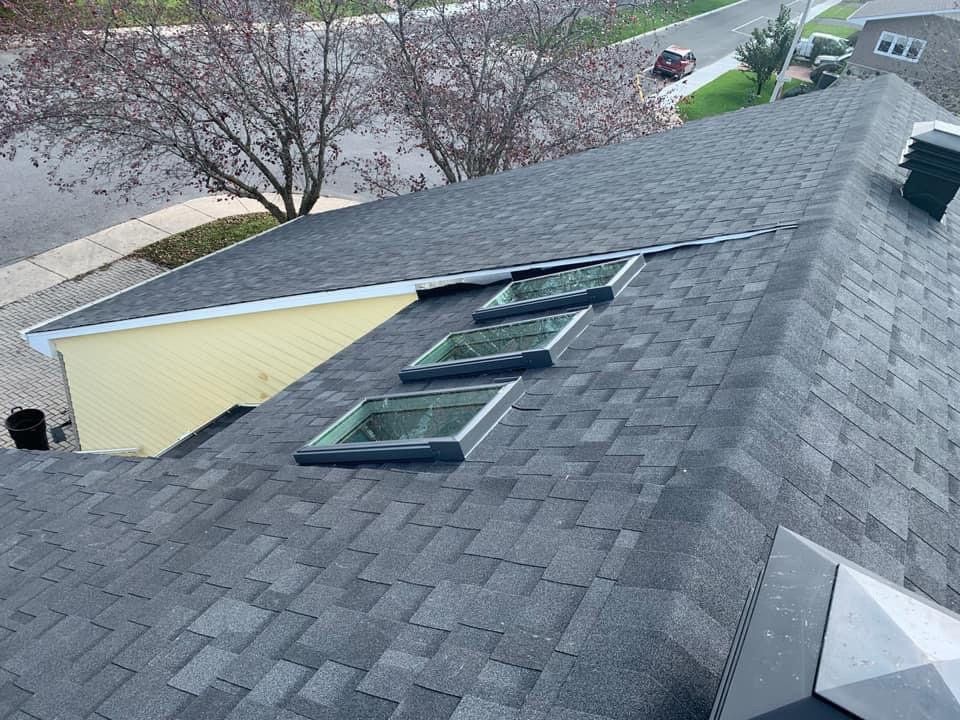 Il y a trois lucarnes sur le toit d'une maison.