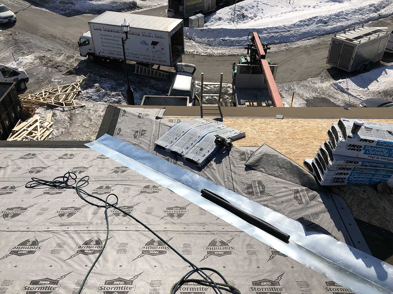 Une vue aérienne d'un toit en construction avec un camion en arrière-plan.