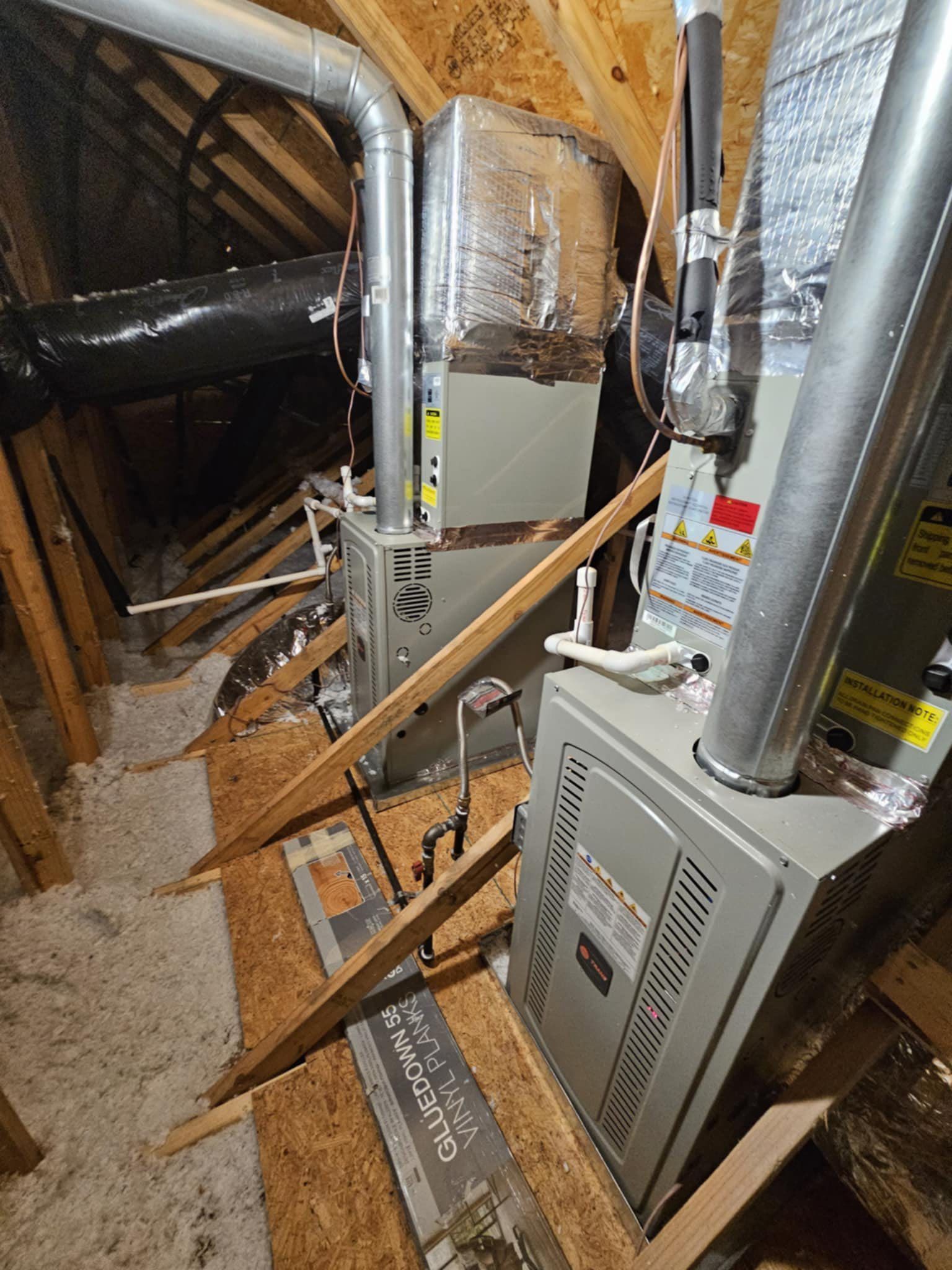 A furnace is sitting in the attic of a house.