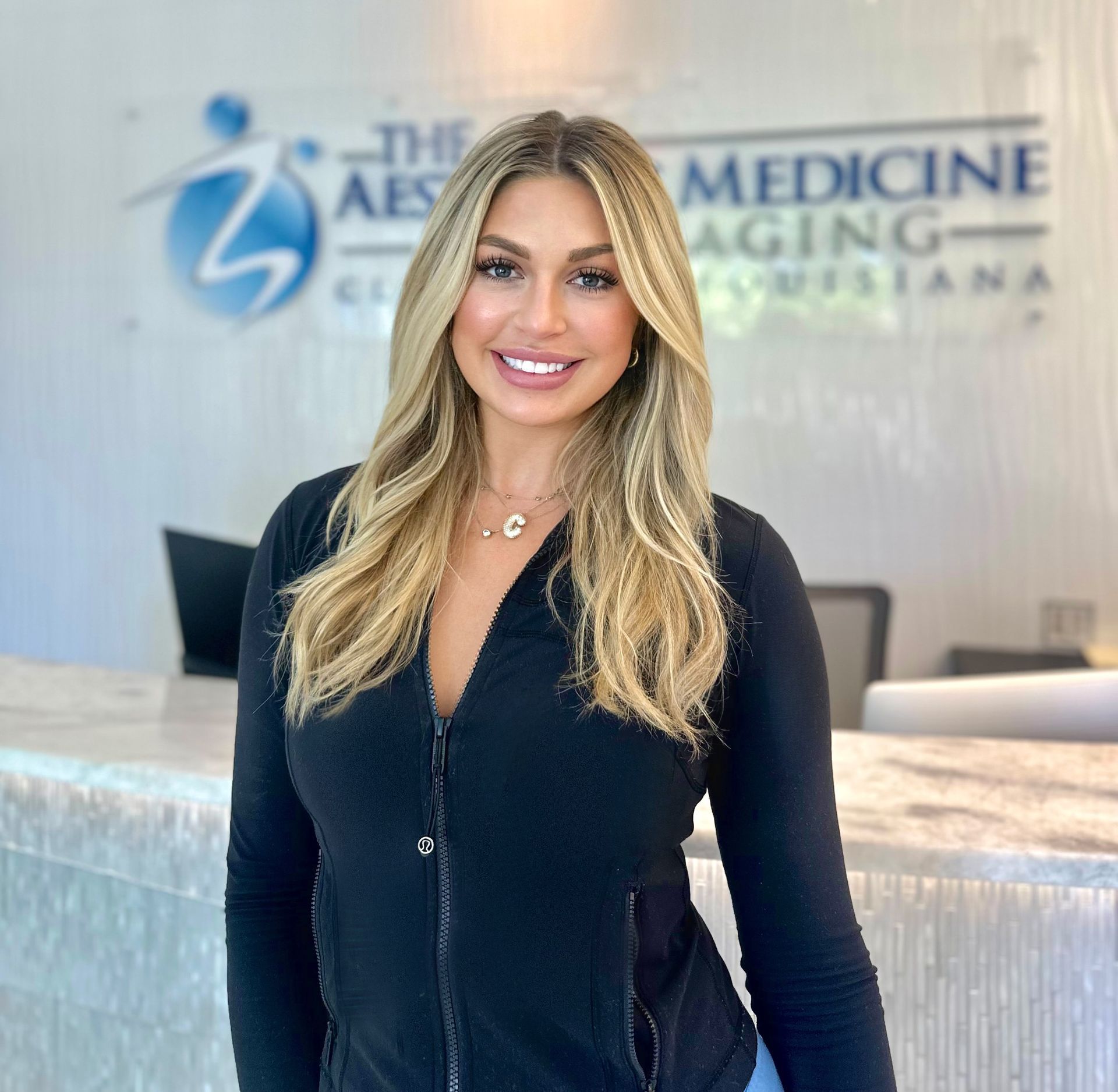 A woman is standing in front of a sign that says medicine aging louisiana.