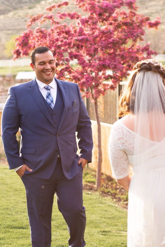 A man in a suit and tie is standing next to a woman in a wedding dress.