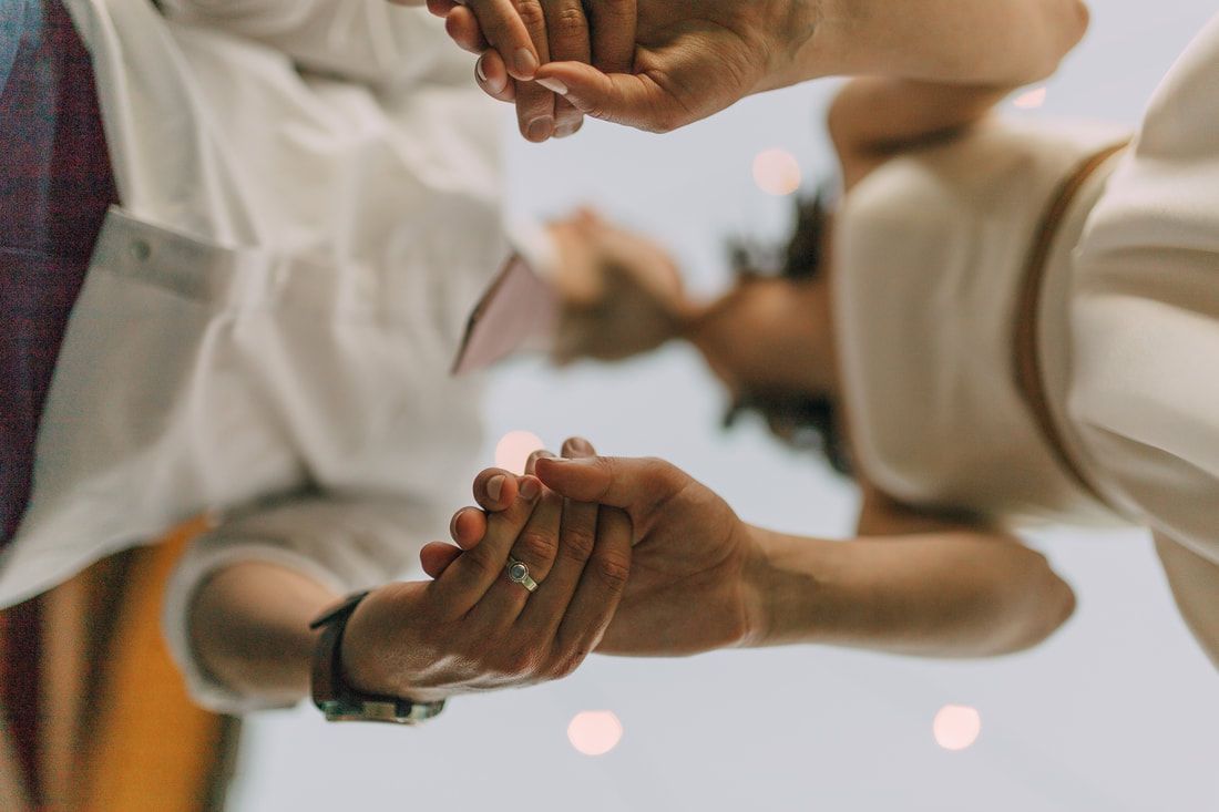 A man and a woman are holding hands in front of a mirror.