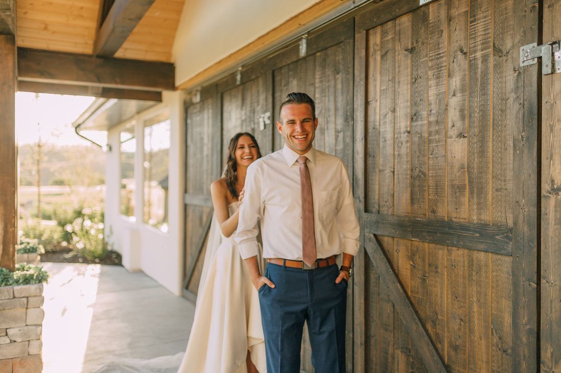 A bride and groom are standing next to each other in front of a wooden door.