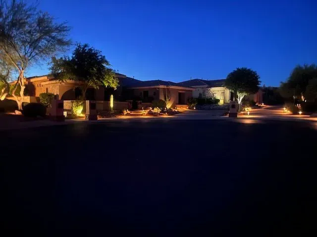 House at night with landscape lighting illuminating the exterior.