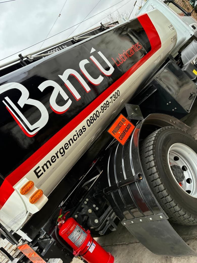 Camión Bancú volcado con un extintor rojo. Diseño en blanco, negro y rojo.