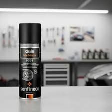 Lata negra de lubricante “Chain Lube Extreme”, en un entorno de garaje.