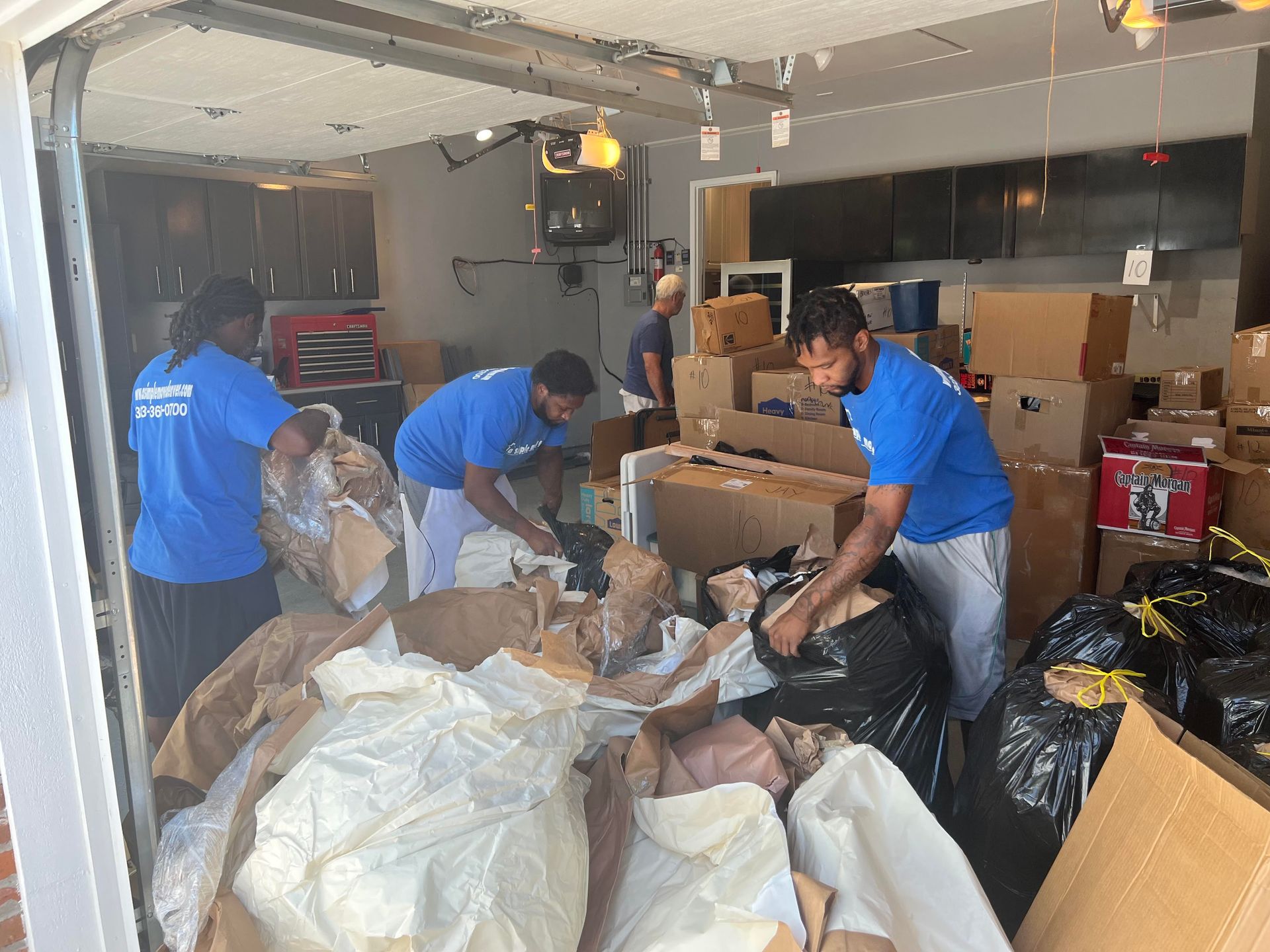 A group of men are moving boxes out of a garage.