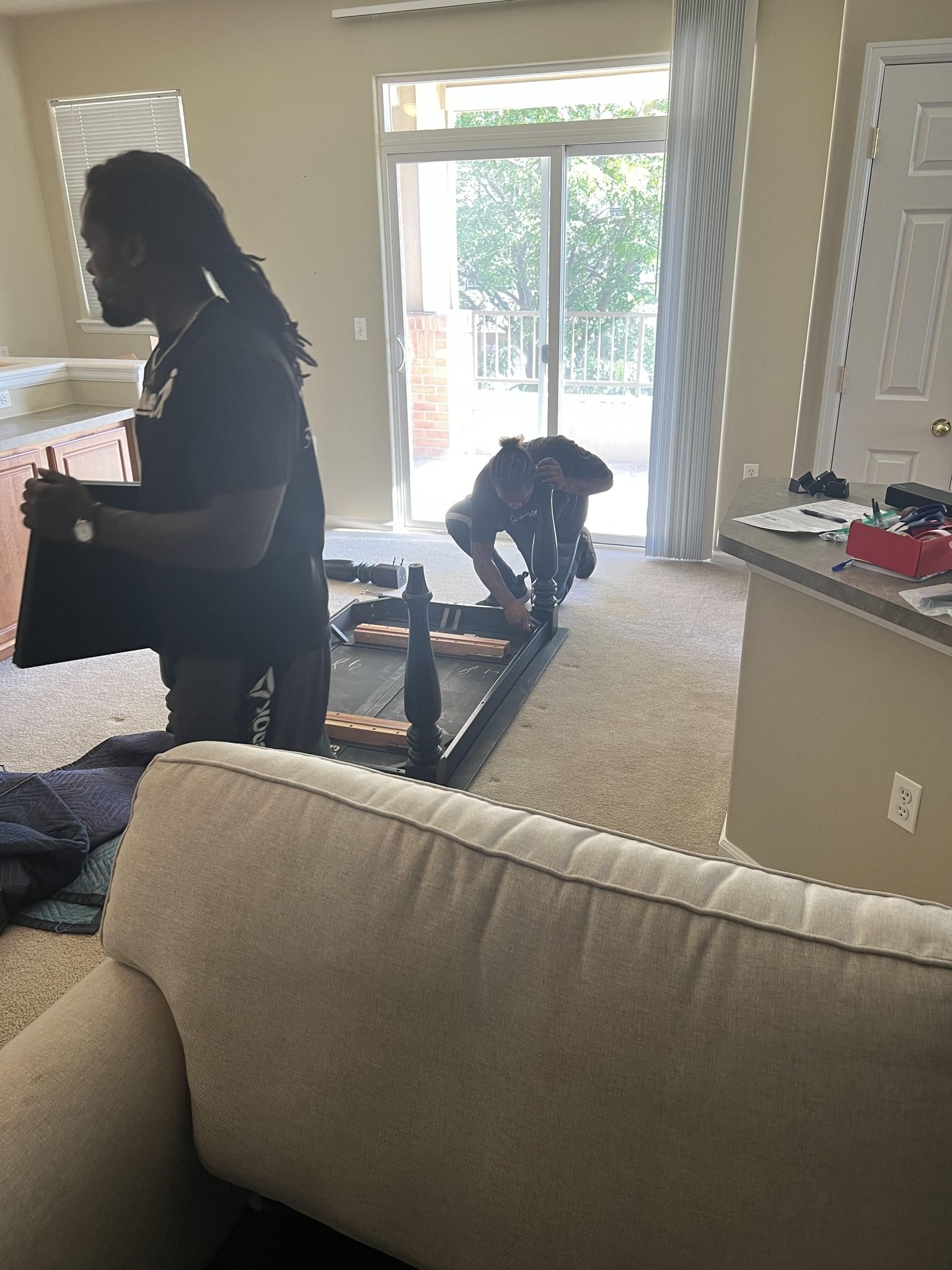Two people are working on a table in a living room.