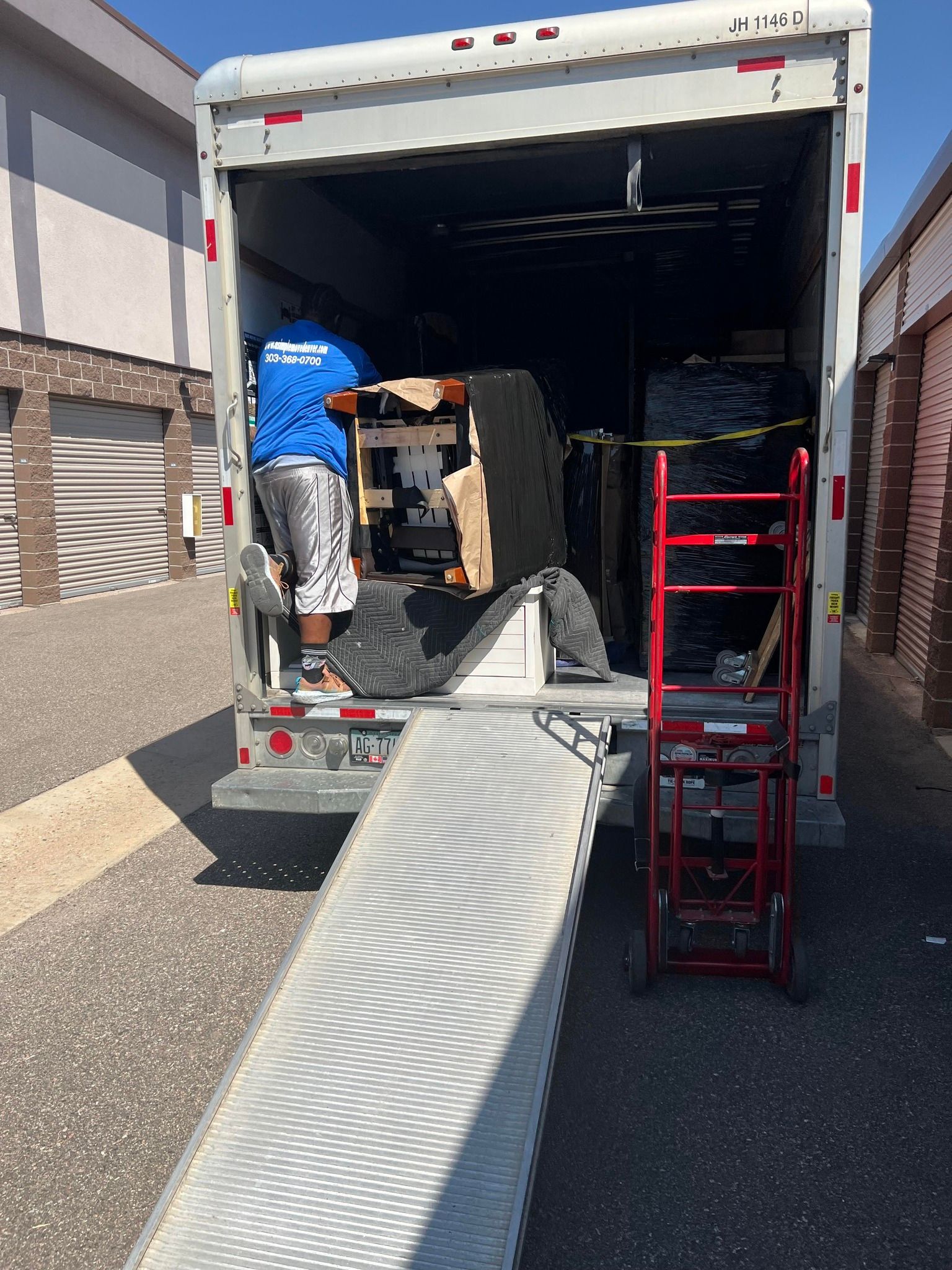 A man is loading a piano into a moving truck.