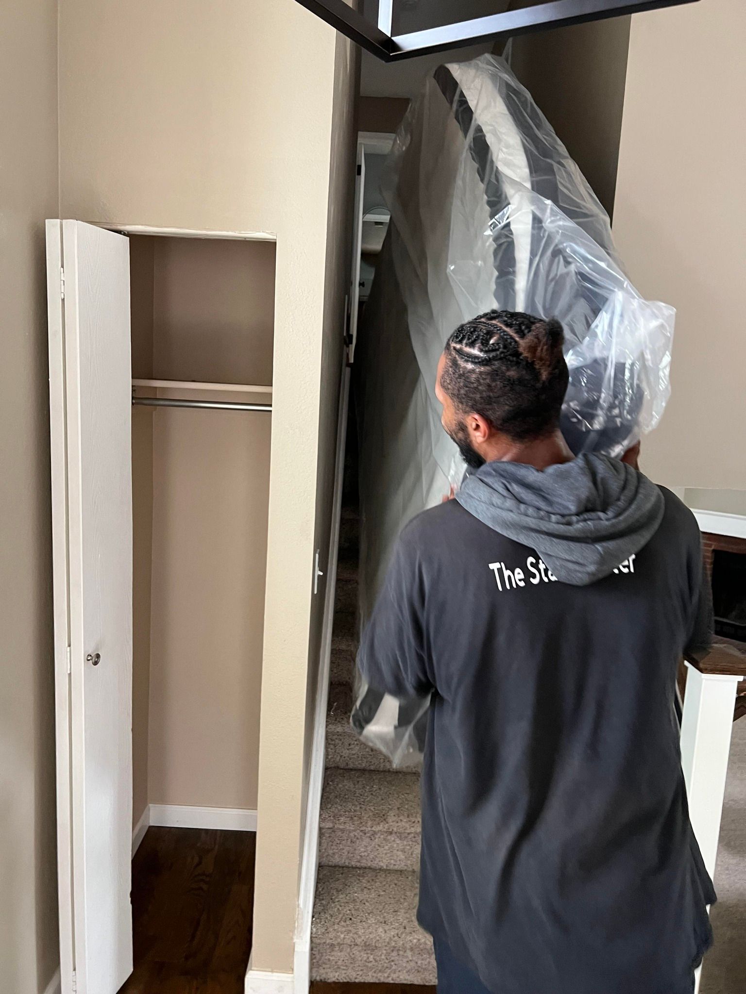 A man is carrying a staircase in a plastic bag.