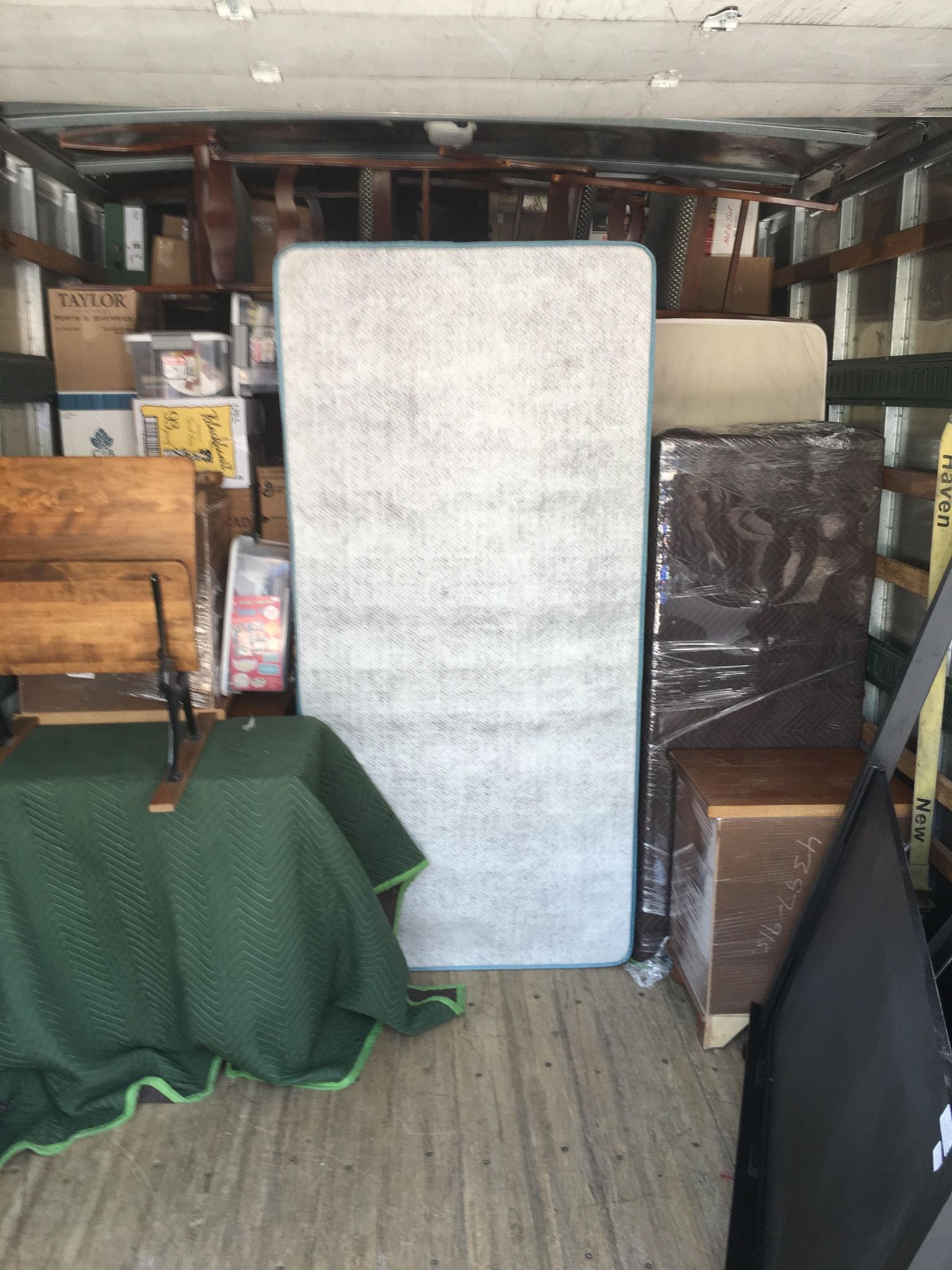 A mattress is sitting in the back of a moving truck.